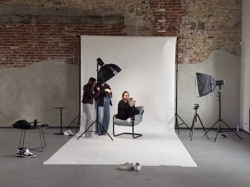 Młodzież podczas zajęć w loftowym studiu fotograficznym - uczestnicy pracują z aparatami i realizują sesję zdjęciową